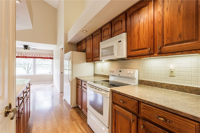 15 Stag Creek Trl, Clarkson, NY 14420 - kitchen with white appliances, light wood-type flooring, brown cabinets, backsplash, and a ceiling fan