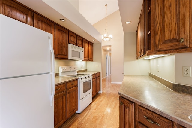 15 Stag Creek Trl, Clarkson, NY 14420 - kitchen with white appliances, decorative backsplash, light wood-type flooring, a chandelier, and brown cabinets