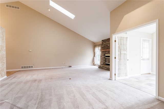 15 Stag Creek Trl, Clarkson, NY 14420 - unfurnished living room featuring carpet flooring, a fireplace, a skylight, high vaulted ceiling, and baseboards