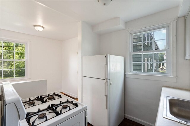 508 W Brighton Ave, Syracuse, NY 13205 - kitchen with white appliances, a sink, baseboards, and light countertops