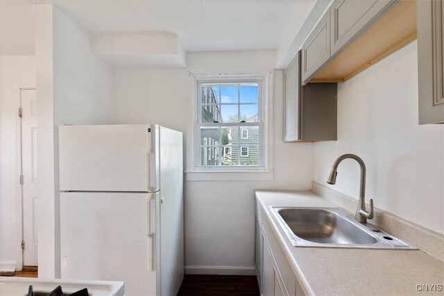 508 W Brighton Ave, Syracuse, NY 13205 - kitchen featuring freestanding refrigerator, a sink, light countertops, baseboards, and gray cabinetry