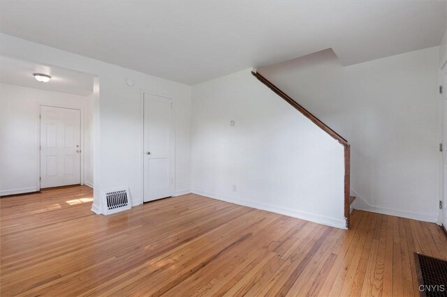 508 W Brighton Ave, Syracuse, NY 13205 - unfurnished living room with stairway, light wood-style floors, and baseboards