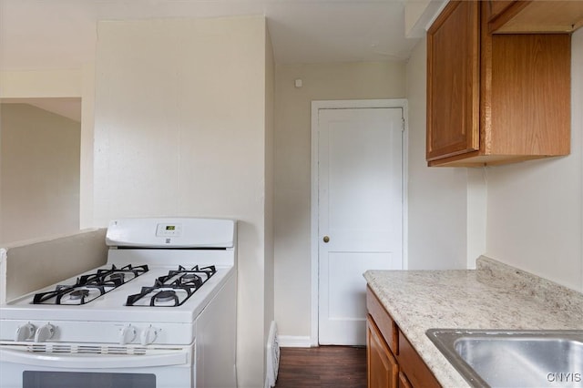 508 W Brighton Ave, Syracuse, NY 13205 - kitchen with gas range gas stove, brown cabinets, and dark wood-style floors