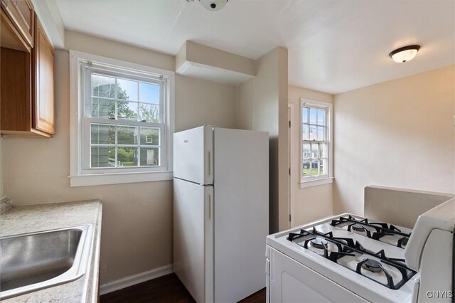 508 W Brighton Ave, Syracuse, NY 13205 - kitchen featuring white appliances, baseboards, light countertops, and a sink
