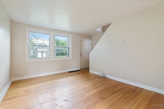 508 W Brighton Ave, Syracuse, NY 13205 - unfurnished living room featuring baseboards, light wood-style floors, and stairway