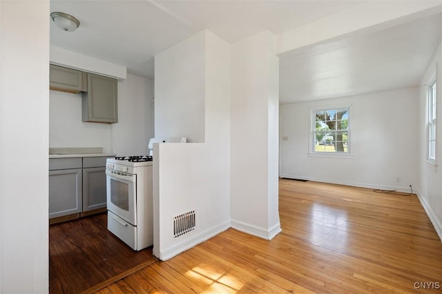 508 W Brighton Ave, Syracuse, NY 13205 - kitchen featuring white range with gas cooktop, gray cabinetry, light wood-style floors, and baseboards