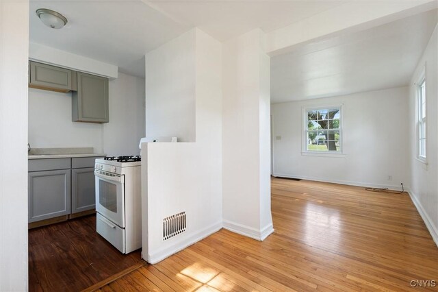 508 W Brighton Ave, Syracuse, NY 13205 - kitchen featuring white gas range, gray cabinets, light wood-style flooring, baseboards, and a sink