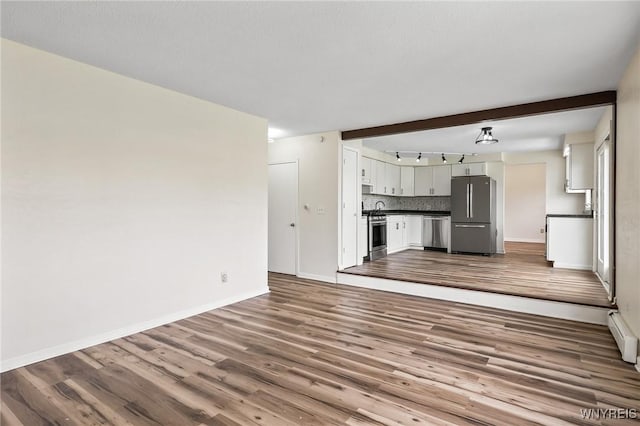 307 Wadsworth Ct, Tonawanda-City, NY 14150 - unfurnished living room featuring dark wood finished floors, baseboards, and a baseboard heating unit