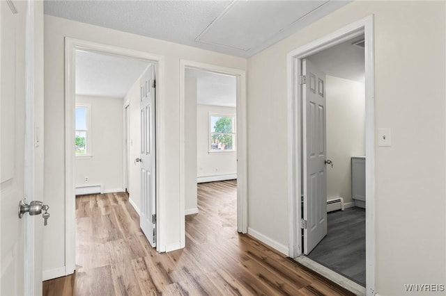 307 Wadsworth Ct, Tonawanda-City, NY 14150 - hall featuring a baseboard heating unit, a baseboard radiator, light wood-type flooring, and baseboards