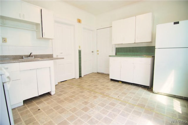 587 Goodyear Ave, Buffalo, NY 14211 - kitchen with freestanding refrigerator, a sink, white cabinetry, light countertops, and tasteful backsplash