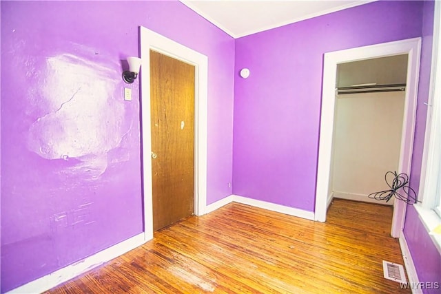 587 Goodyear Ave, Buffalo, NY 14211 - unfurnished bedroom with wood finished floors, a closet, baseboards, and ornamental molding