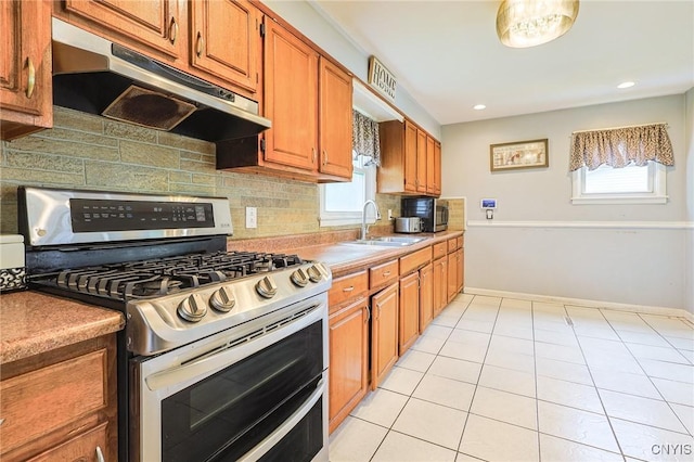 115 Matterson Ave, Camillus, NY 13219 - kitchen with appliances with stainless steel finishes, under cabinet range hood, a sink, tasteful backsplash, and light tile patterned flooring