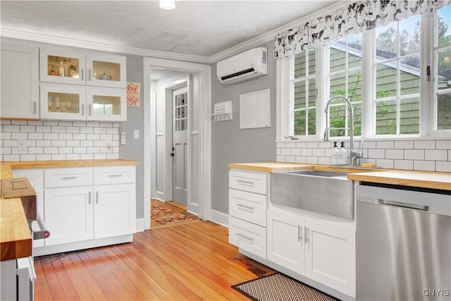 2875 W Lake Rd, Cazenovia, NY 13035 - kitchen with butcher block countertops, stainless steel dishwasher, an AC wall unit, decorative backsplash, and a sink