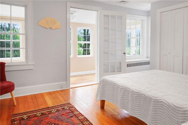 2875 W Lake Rd, Cazenovia, NY 13035 - bedroom featuring radiator, wood finished floors, baseboards, and a closet