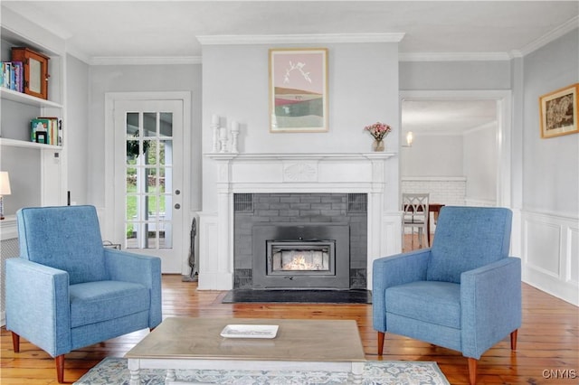 2875 W Lake Rd, Cazenovia, NY 13035 - living area featuring wood finished floors, ornamental molding, a fireplace with flush hearth, and a wainscoted wall