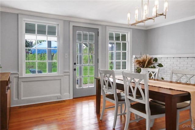 2875 W Lake Rd, Cazenovia, NY 13035 - dining room with ornamental molding, a chandelier, wood finished floors, a wainscoted wall, and a decorative wall