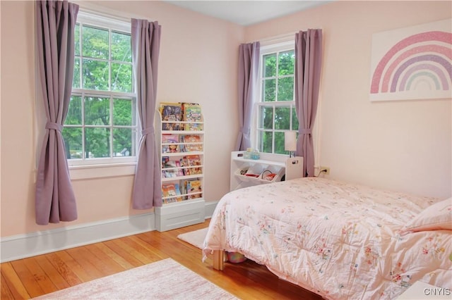 2875 W Lake Rd, Cazenovia, NY 13035 - bedroom featuring multiple windows, wood finished floors, and baseboards