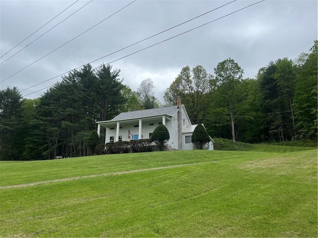 1217 County Highway 34, Westford, NY 12155 - view of front of home featuring covered porch, a chimney, a front yard, and a wooded view