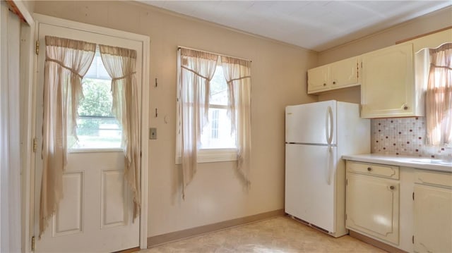 15 Wycliffe Rd, Waterloo, NY 13165 - kitchen featuring freestanding refrigerator, plenty of natural light, tasteful backsplash, and ornamental molding