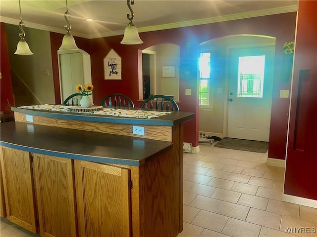80 Sunnydale Ave, Wellsville, NY 14895 - kitchen with dark countertops, a center island, crown molding, decorative light fixtures, and arched walkways