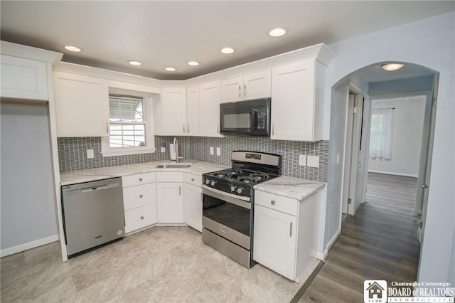 10595 Linwood Dr, Dunkirk-Town, NY 14048 - kitchen with stainless steel appliances, arched walkways, white cabinets, and recessed lighting