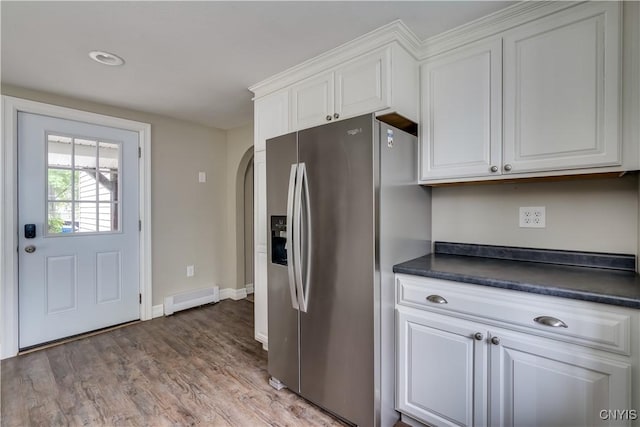 152 Leray St, Le Ray, NY 13612 - kitchen featuring stainless steel refrigerator with ice dispenser, a baseboard heating unit, dark countertops, arched walkways, and recessed lighting
