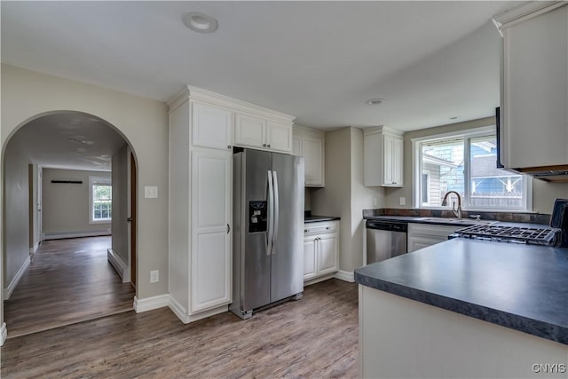 152 Leray St, Le Ray, NY 13612 - kitchen with stainless steel appliances, dark countertops, light wood-type flooring, arched walkways, and a sink