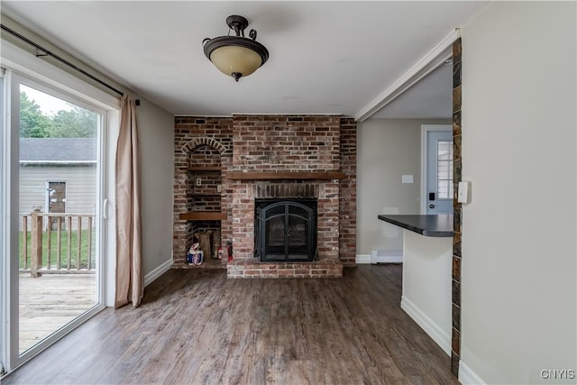 152 Leray St, Le Ray, NY 13612 - unfurnished living room with a brick fireplace, wood finished floors, and baseboards