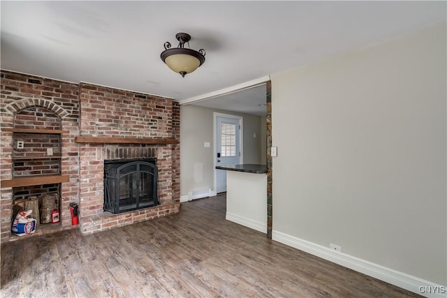 152 Leray St, Le Ray, NY 13612 - unfurnished living room featuring a fireplace, baseboards, wood finished floors, and baseboard heating