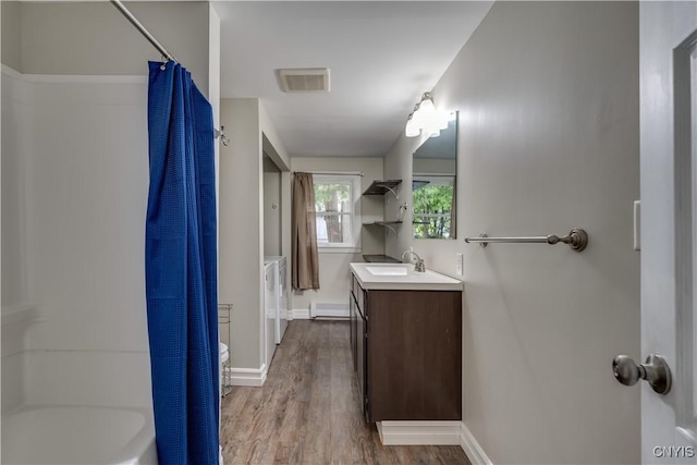 152 Leray St, Le Ray, NY 13612 - full bathroom with wood finished floors, vanity, baseboards, shower / tub combo, and a baseboard radiator