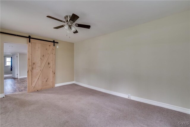 152 Leray St, Le Ray, NY 13612 - carpeted empty room featuring ceiling fan, a barn door, and baseboards