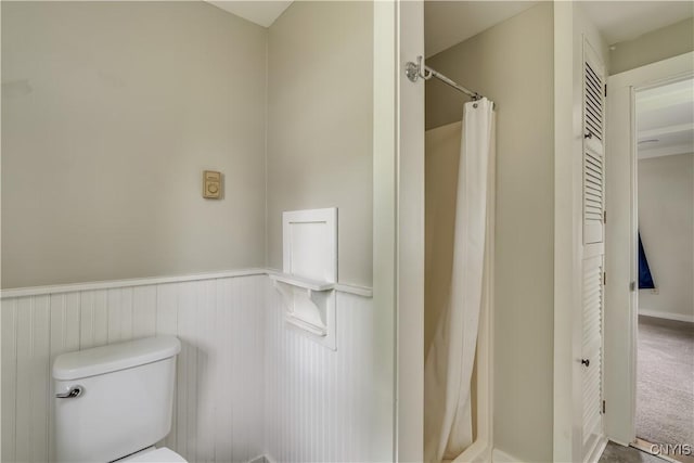 152 Leray St, Le Ray, NY 13612 - bathroom featuring a wainscoted wall, toilet, and curtained shower
