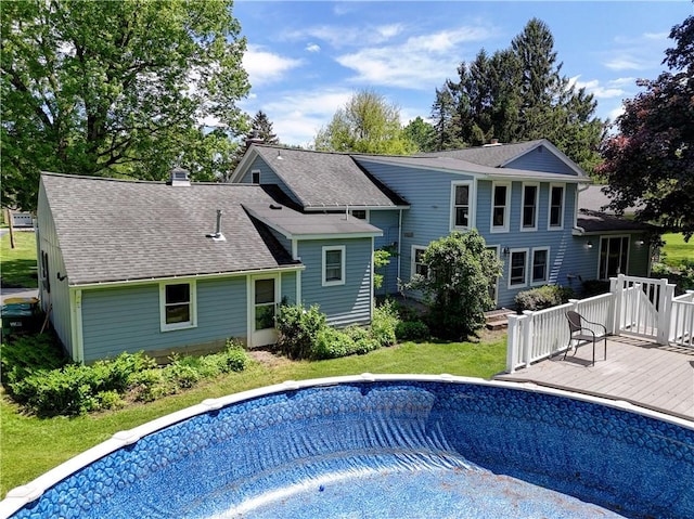 37 York St, Mendon, NY 14472 - rear view of house featuring a wooden deck, an empty pool, roof with shingles, a chimney, and a yard