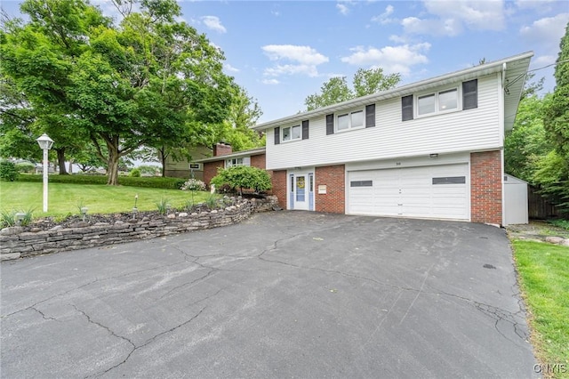 310 Wedgewood Ter, Dewitt, NY 13214 - view of front facade with asphalt driveway, brick siding, an attached garage, and a front lawn