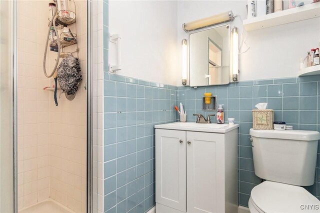 310 Wedgewood Ter, Dewitt, NY 13214 - full bath featuring a stall shower, toilet, tile walls, vanity, and a wainscoted wall