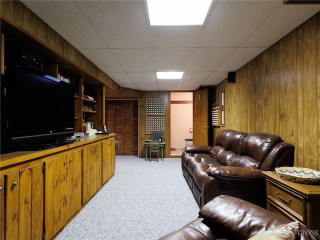 916 State St, Wilna, NY 13619 - living room with light carpet, wood walls, and a paneled ceiling
