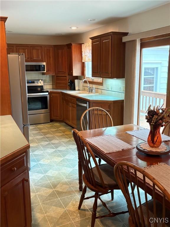 74 Eaton St, Hamilton, NY 13346 - kitchen with stainless steel appliances, a sink, light countertops, light floors, and tasteful backsplash