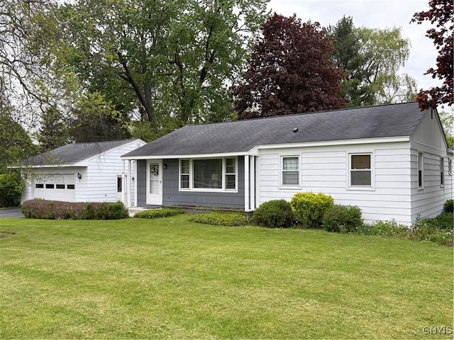 74 Eaton St, Hamilton, NY 13346 - single story home featuring a front lawn, roof with shingles, and a detached garage