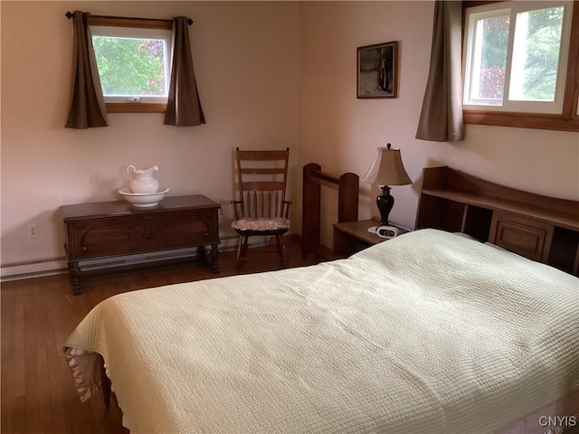 74 Eaton St, Hamilton, NY 13346 - bedroom featuring multiple windows, a baseboard radiator, wood finished floors, and baseboards
