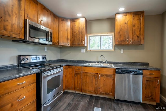 2707 State Route 48, Minetto, NY 13115 - kitchen featuring stainless steel appliances, a sink, brown cabinetry, dark countertops, and dark wood-type flooring