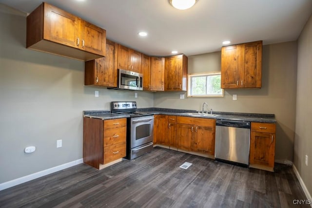 2707 State Route 48, Minetto, NY 13115 - kitchen featuring appliances with stainless steel finishes, brown cabinetry, dark countertops, dark wood-type flooring, and baseboards