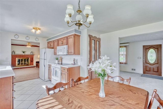 173 Dorian Ln, Greece, NY 14626 - dining space featuring light carpet, a chandelier, ceiling fan, light tile patterned floors, and a brick fireplace