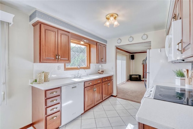 173 Dorian Ln, Greece, NY 14626 - kitchen with white dishwasher, a sink, light countertops, light carpet, and brown cabinetry
