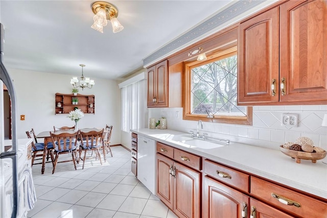 173 Dorian Ln, Greece, NY 14626 - kitchen with a sink, dishwasher, light countertops, a chandelier, and light tile patterned floors