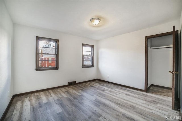 417 24th St, Niagara Falls, NY 14303 - unfurnished bedroom with light wood-style flooring, baseboards, and a closet