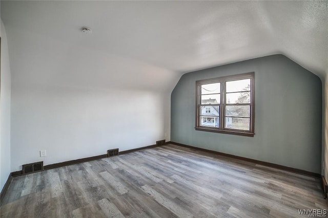 417 24th St, Niagara Falls, NY 14303 - additional living space featuring lofted ceiling, wood finished floors, baseboards, and a textured ceiling