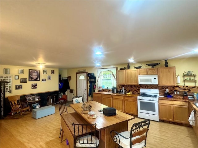 405 County Highway 12, Laurens, NY 13796 - kitchen with white appliances, light wood-type flooring, decorative backsplash, and a breakfast bar