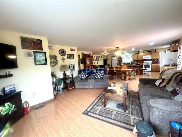 405 County Highway 12, Laurens, NY 13796 - living area with light wood-type flooring, ceiling fan, and baseboards