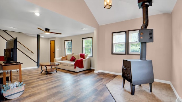 7926 Margaretta Rd, Sodus, NY 14555 - living room featuring a wood stove, baseboards, stairway, ceiling fan, and wood finished floors