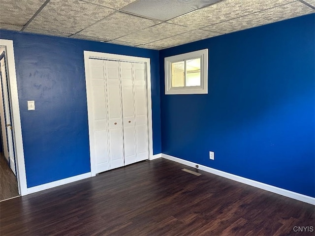 442 Euclid Rd, Utica, NY 13502 - unfurnished bedroom featuring dark wood-style flooring, baseboards, and a paneled ceiling